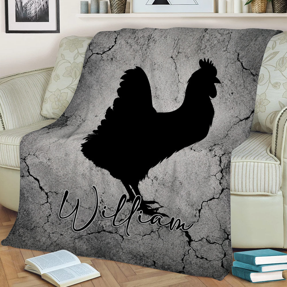 Black chicken artwork on a gray cracked-stone blanket displayed on a couch
