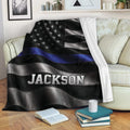 Police blanket displayed on a sofa with black and silver flag artwork and blue line detail