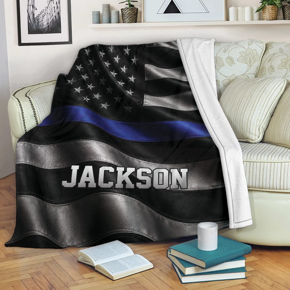 Police blanket displayed on a sofa with black and silver flag artwork and blue line detail