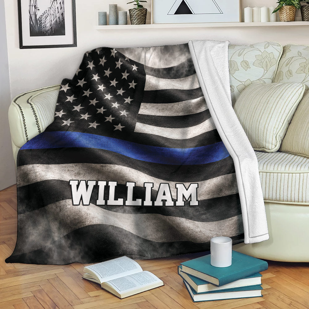 Police blanket draped over a sofa with a blue line flag design in a cozy living room