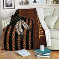 Native American blanket draped over a sofa with feather artwork and colorful geometric textile patterns