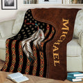 Native American throw blanket displayed on a sofa with feathers, bead details, and rustic geometric artwork