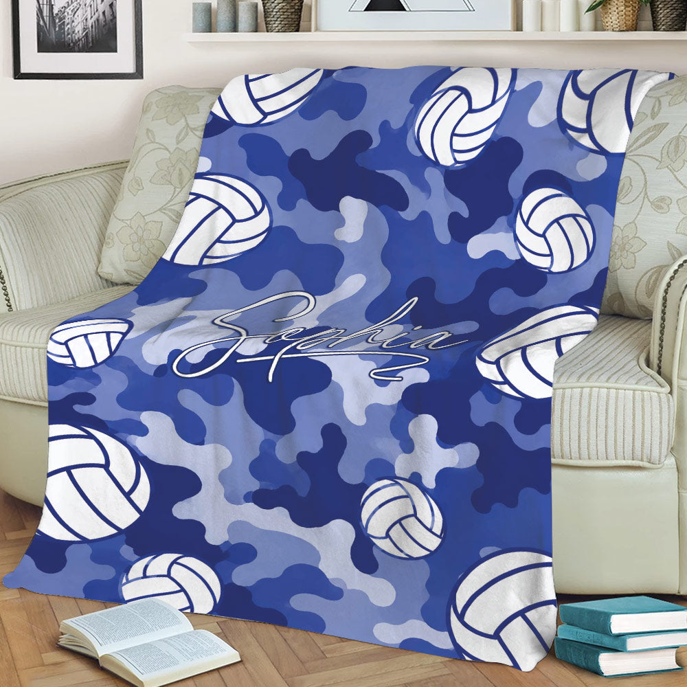 Blue camouflage volleyball blanket spread across a sofa with repeating white volleyball illustrations