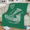 Green volleyball throw blanket displayed on a sofa with sketch-style sports artwork