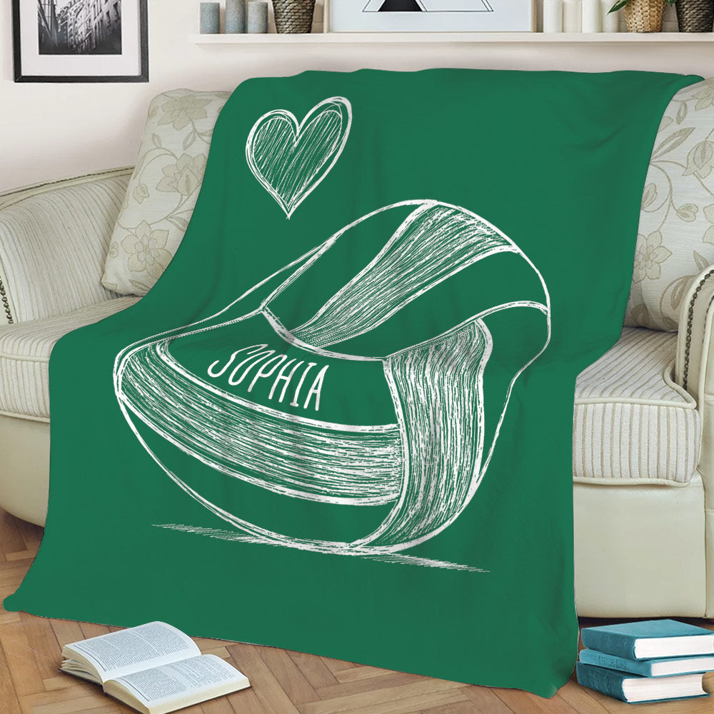 Green volleyball throw blanket displayed on a sofa with sketch-style sports artwork