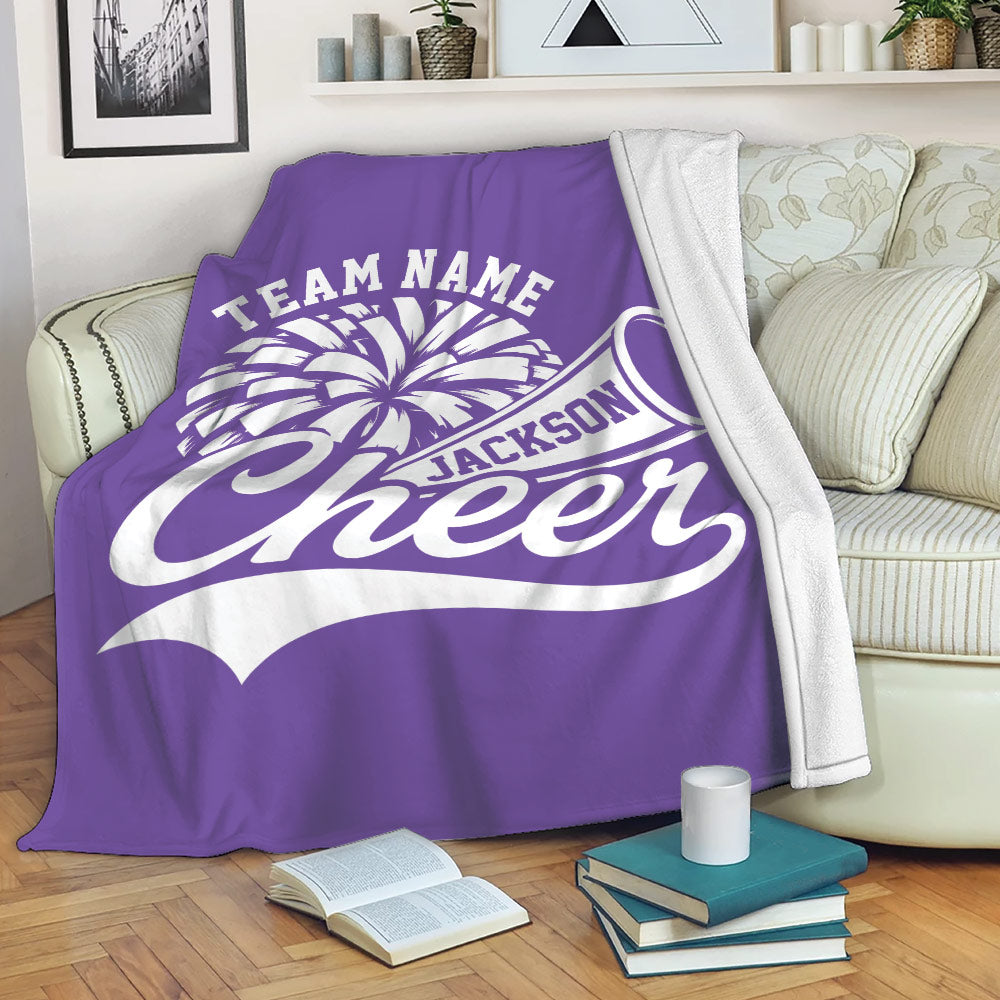 Purple cheerleading blanket draped over a sofa with pom-pom and megaphone design