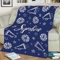 Navy blue cheerleading throw blanket displayed on a sofa with pom-poms, megaphones, and stars