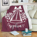 Maroon cheerleading blanket displayed on a sofa with megaphone and pom-pom design