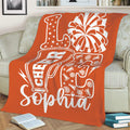 Orange cheerleading throw blanket on a sofa with bold megaphone and pom-pom artwork