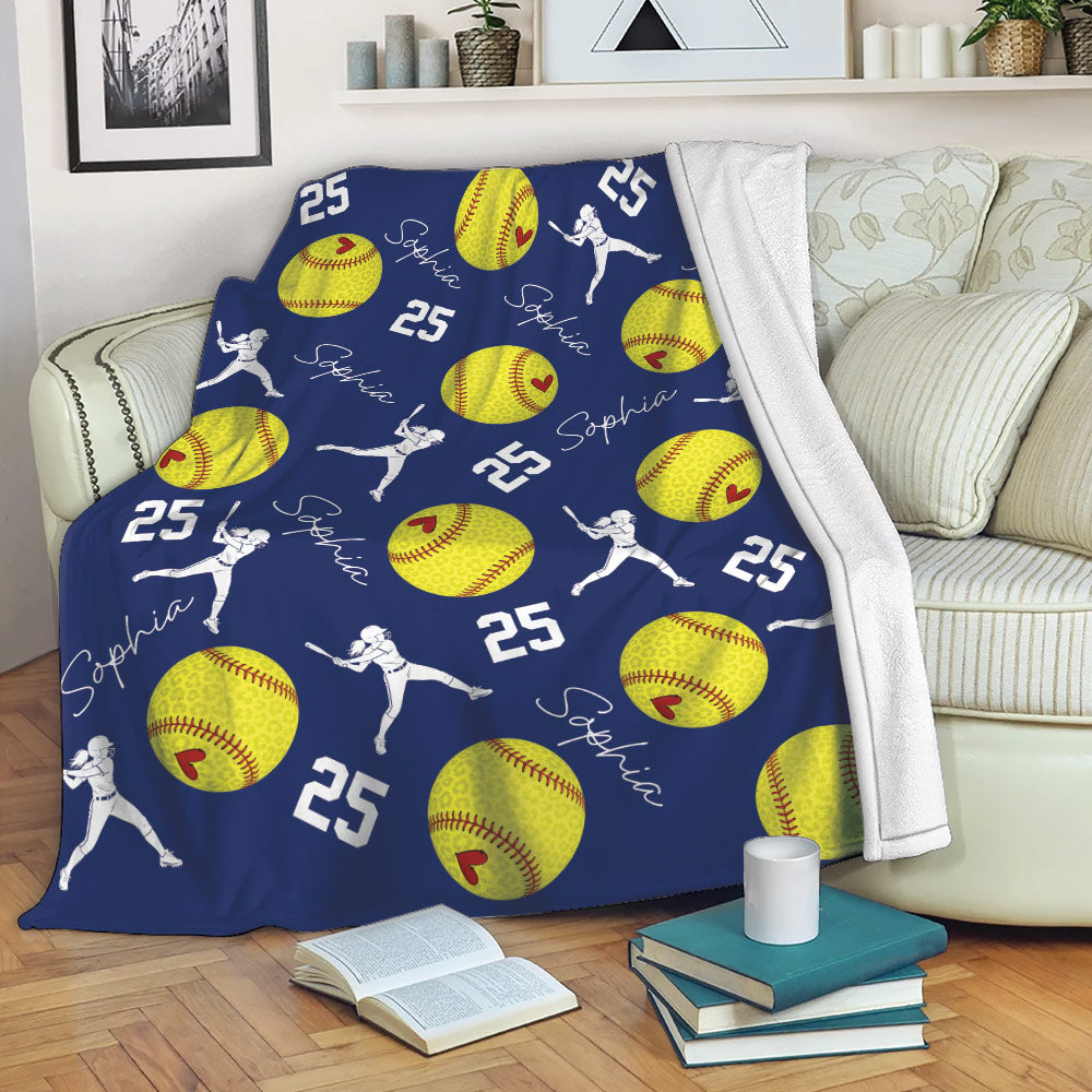Navy softball throw blanket draped over a sofa with yellow softball and player artwork