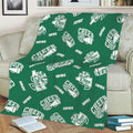 Green cheerleading blanket displayed on a sofa with repeating white cheer artwork