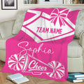 Pink cheerleading blanket on a sofa with bold pom-pom and megaphone artwork