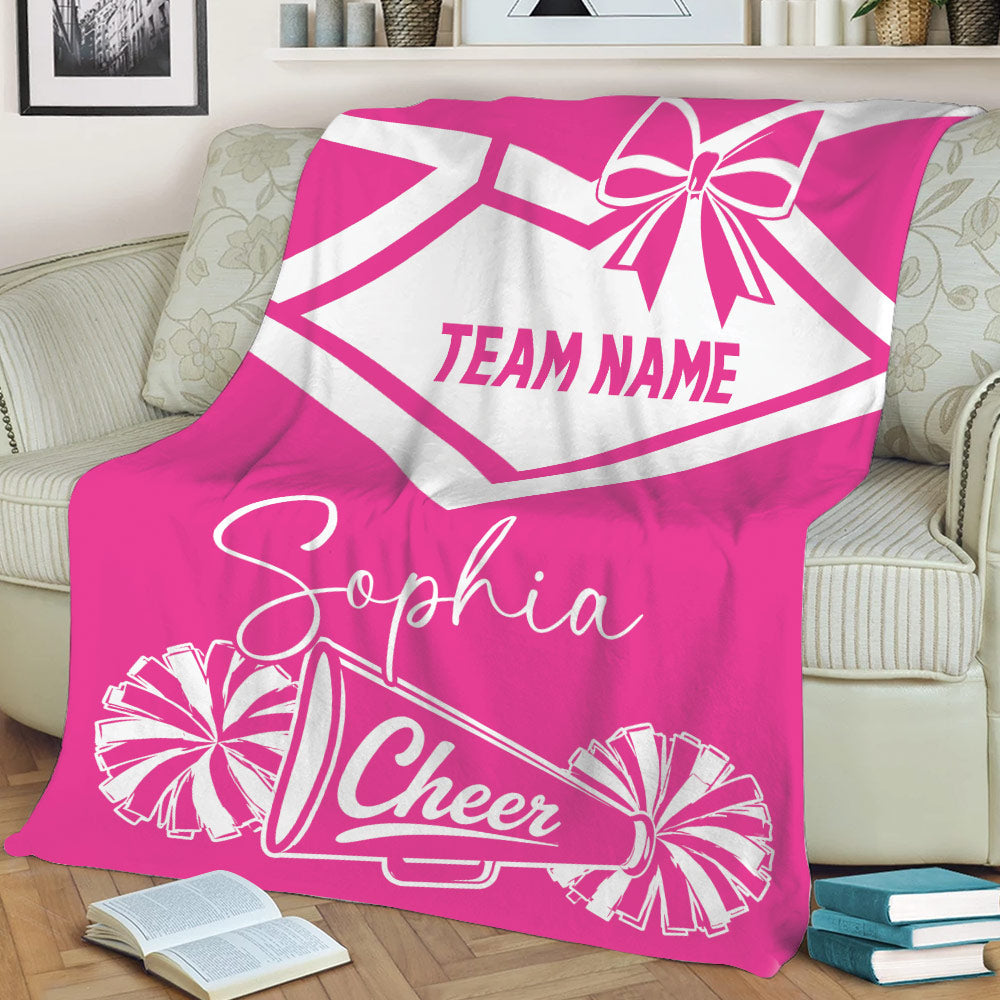 Pink cheerleading blanket on a sofa with bold pom-pom and megaphone artwork