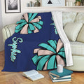 Cheerleading blanket draped over a sofa with teal and beige pom-pom artwork
