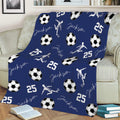 Navy soccer throw blanket draped over a sofa with soccer balls and active player artwork