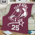 Maroon soccer throw blanket on a sofa featuring large soccer ball artwork and a bold athletic design