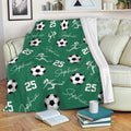 Green soccer throw blanket draped over a sofa with soccer balls and female player silhouettes