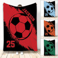 Custom soccer blanket with bold black ball artwork shown in red, blue, orange, and green color choices