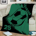 Green and black soccer blanket spread across a sofa with oversized soccer ball artwork