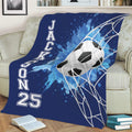 Navy blue soccer throw blanket displayed on a sofa with a netted ball and dynamic blue artwork