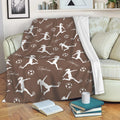 Brown soccer throw blanket draped over a sofa with player silhouettes, soccer balls, and cozy lounge styling