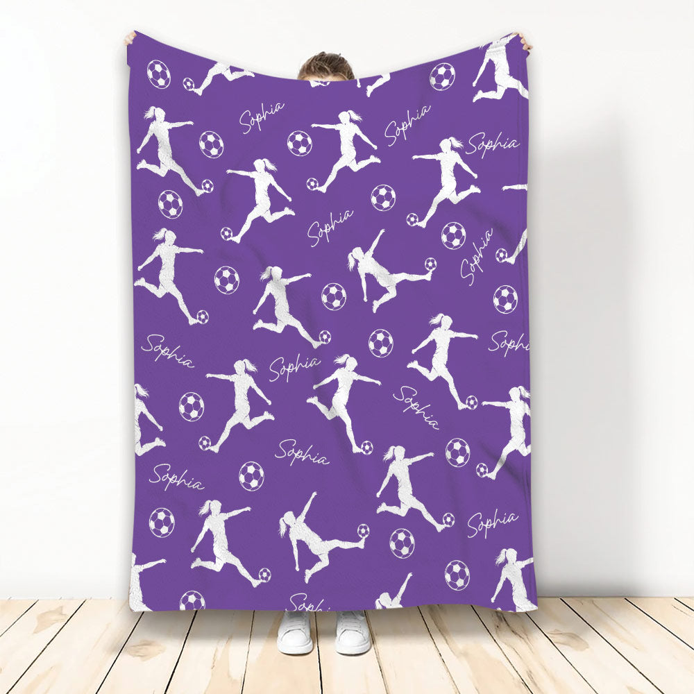 Purple soccer throw blanket displaying repeating soccer player silhouettes and soccer ball artwork