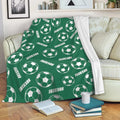 Green soccer throw blanket draped over a sofa with repeating soccer ball design