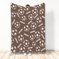 Brown soccer blanket displayed vertically with repeating white soccer ball artwork