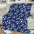 Navy blue soccer throw blanket spread across a sofa with repeating soccer ball pattern