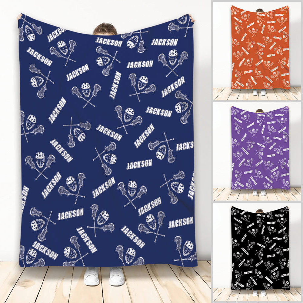 Navy lacrosse throw blanket with repeating sticks, protective helmets, balls, and athletic artwork