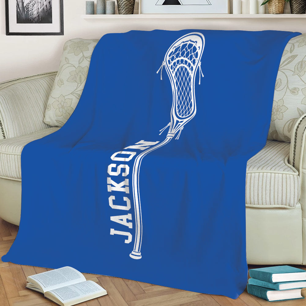 Blue lacrosse throw blanket spread across a sofa with large white lacrosse artwork