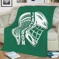 Green lacrosse throw blanket spread across a sofa with bold white lacrosse artwork