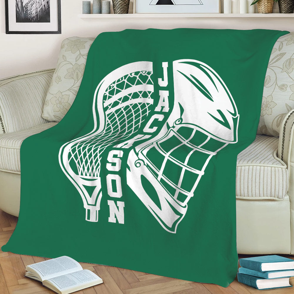 Green lacrosse throw blanket spread across a sofa with bold white lacrosse artwork
