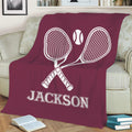 Maroon tennis throw blanket displaying crossed racquets and tennis ball artwork on a sofa