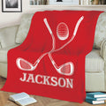 Red golf throw blanket with crossed clubs and golf ball draped across a sofa