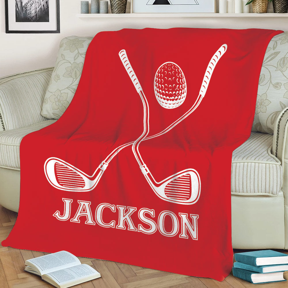 Red golf throw blanket with crossed clubs and golf ball draped across a sofa