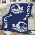 Navy swimming blanket displayed on a sofa with large white swimmer silhouettes