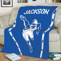Blue swimmer blanket displayed across a sofa with athletic pool-inspired artwork