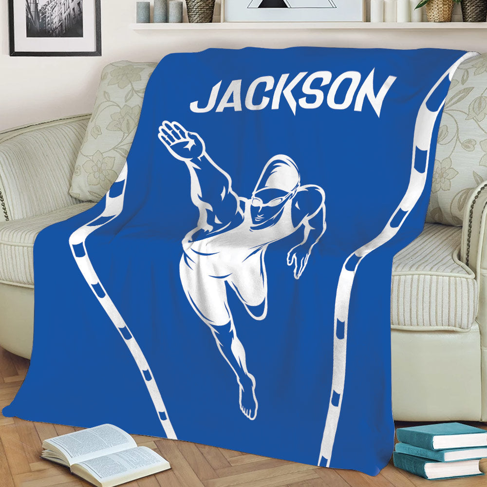 Blue swimmer blanket displayed across a sofa with athletic pool-inspired artwork