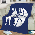 Navy basketball throw blanket on a sofa with a dynamic player silhouette and large white basketball design
