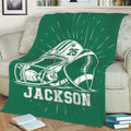 Green football throw blanket draped over a sofa with helmet and football design
