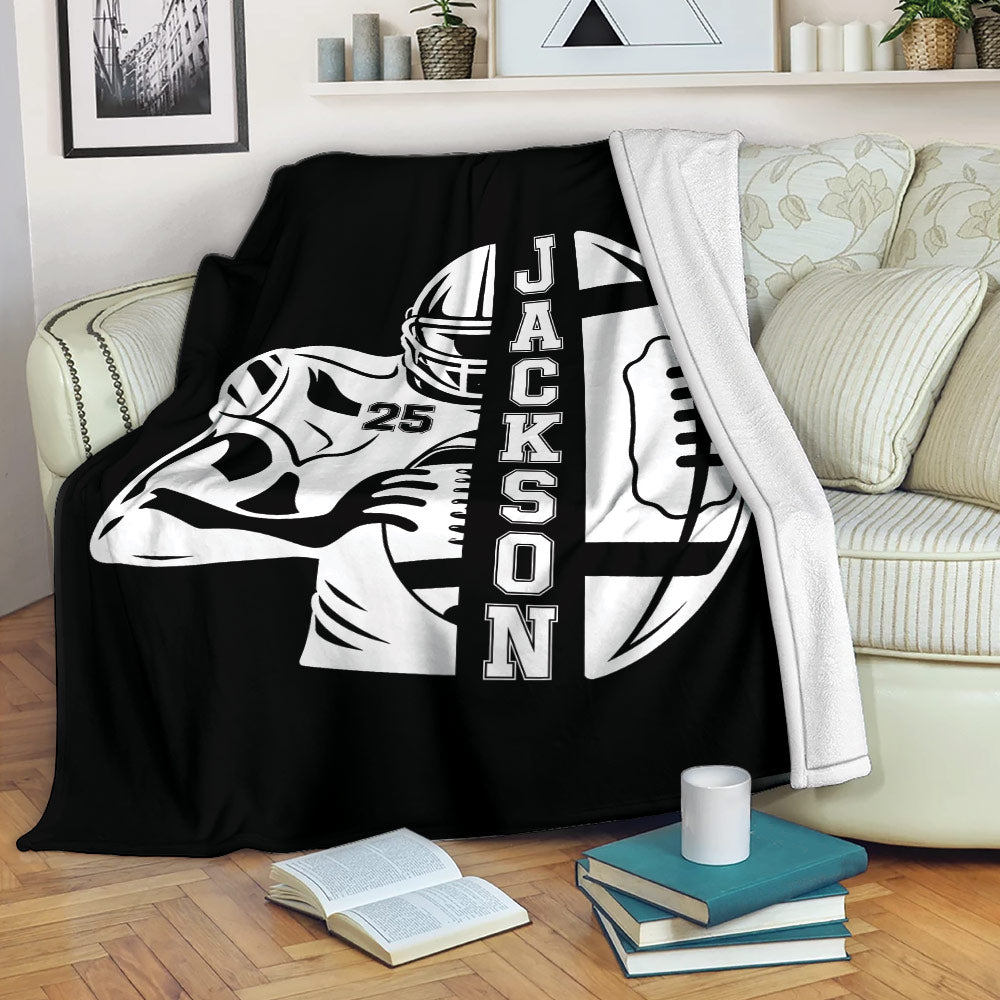 Black football blanket styled on a sofa with a helmeted player and football graphic