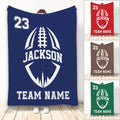 Football throw blanket with bold stylized football artwork shown in multiple team color options