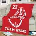 Red football throw blanket arranged on a sofa with large white football artwork