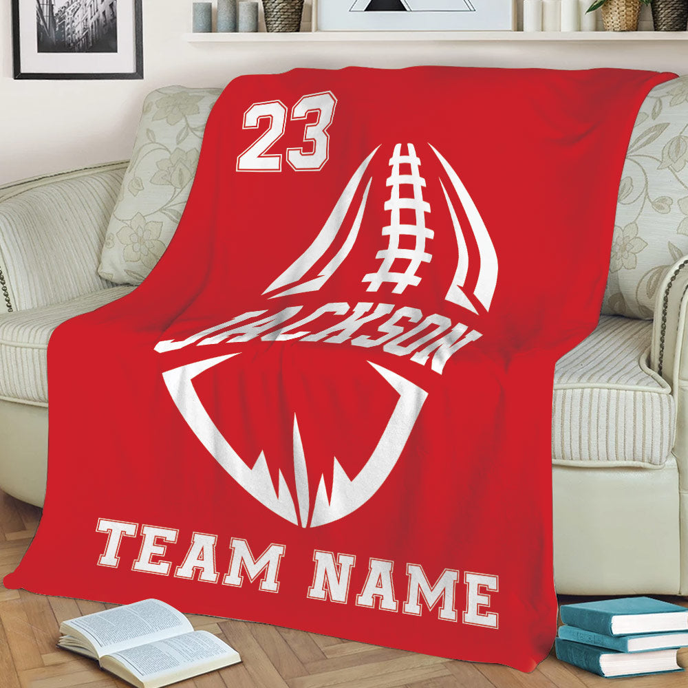 Red football throw blanket arranged on a sofa with large white football artwork