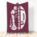 Maroon football blanket featuring a helmeted player silhouette and bold football design