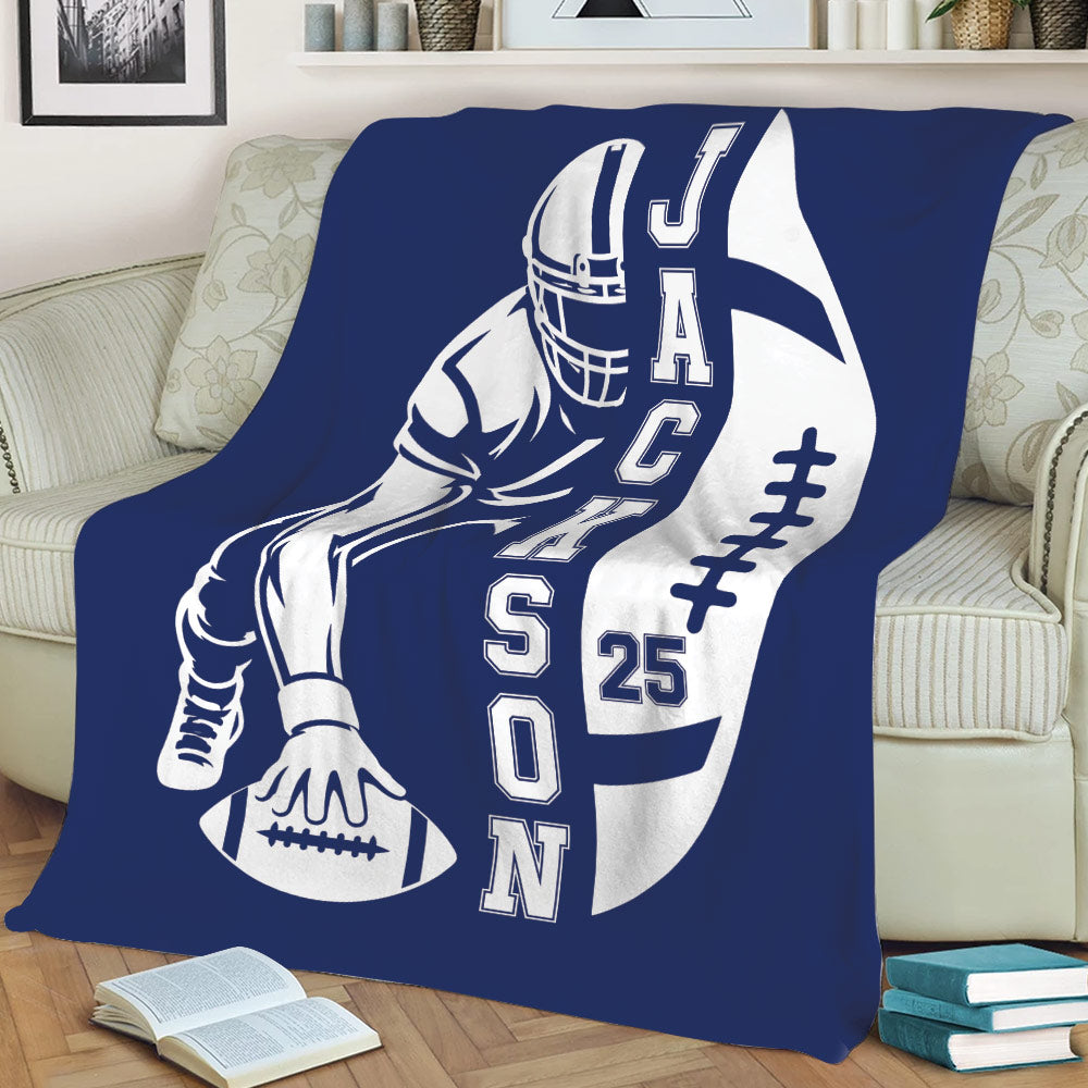 Navy football throw blanket draped over a sofa with bold player and football artwork