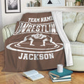 Brown wrestling blanket draped over a sofa with grappler artwork and bold sports lettering
