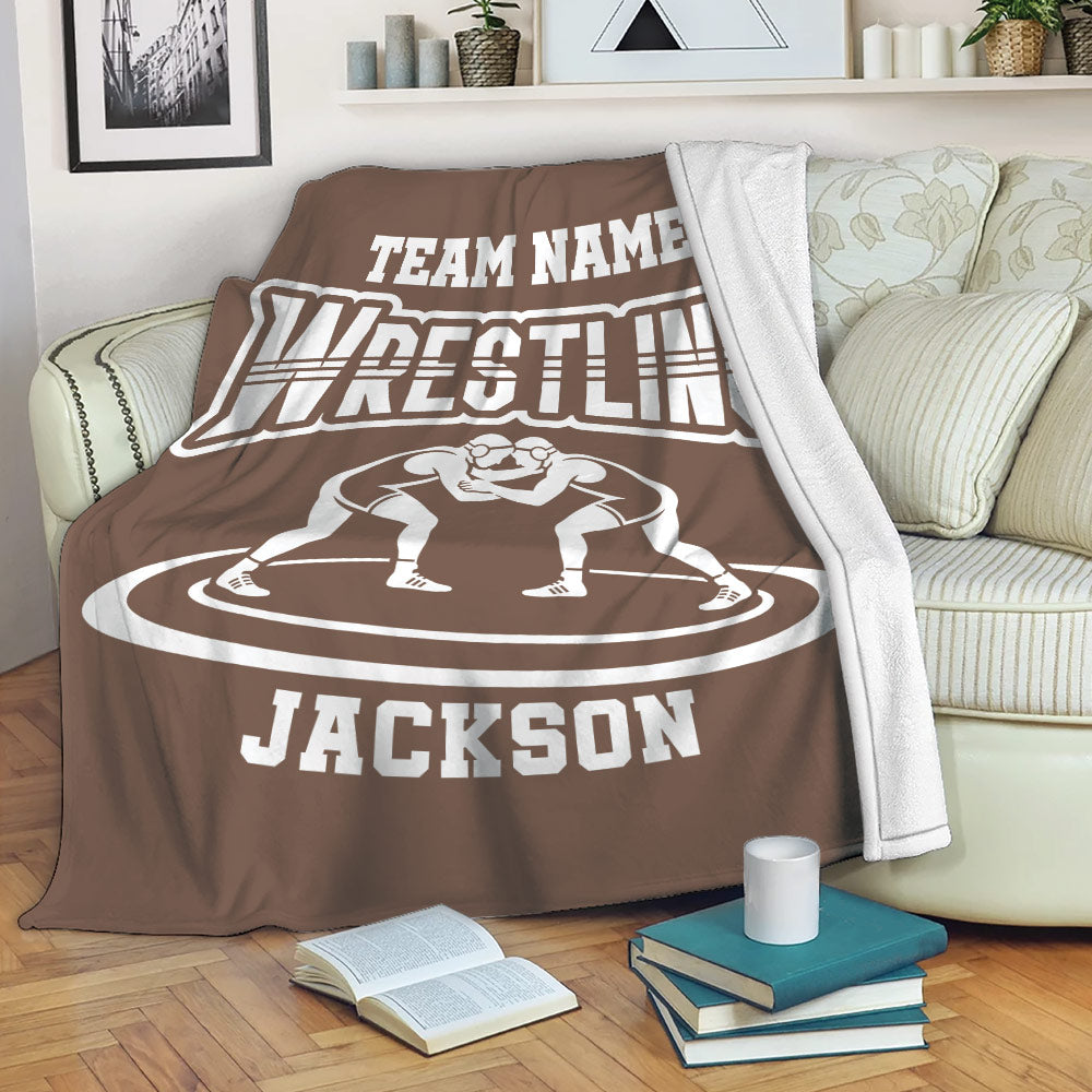 Brown wrestling blanket draped over a sofa with grappler artwork and bold sports lettering