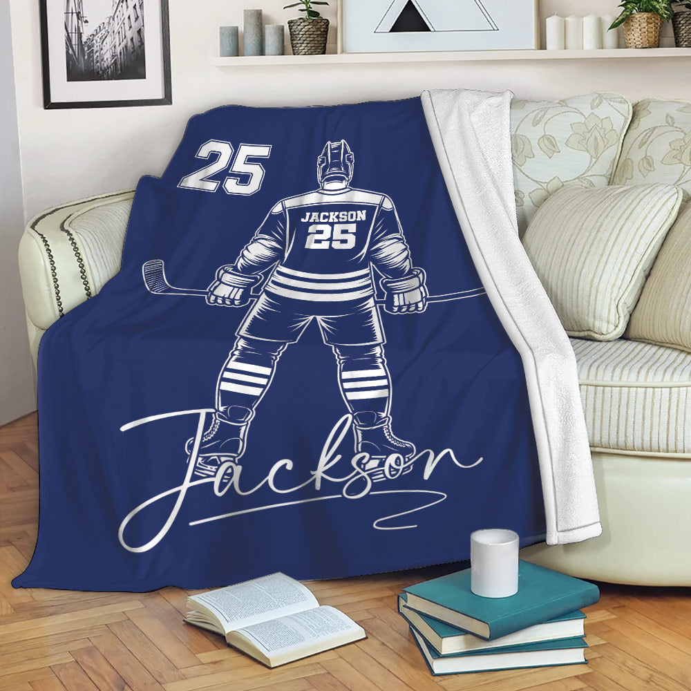 Blue hockey throw blanket draped over a sofa, featuring a skater illustration and bold sports artwork